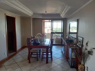 Uma sala de jantar com mesa de madeira e portas de vidro no fundo.