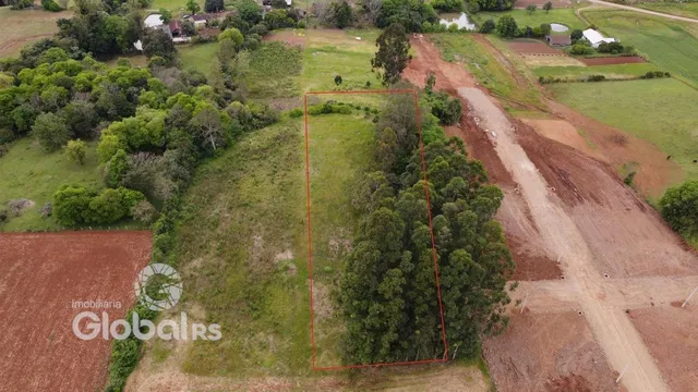 Vista aérea de uma propriedade rural com vegetação e estradas de terra.