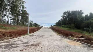 Uma estrada pavimentada se estende por uma área de terra com vegetação ao redor.