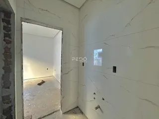 Vista de um corredor com uma abertura para outro ambiente em uma propriedade.