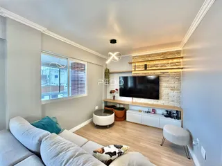 Sala de estar moderna com sofá e televisão em um apartamento no Brasil.