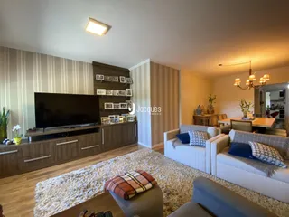 Sala de estar com sofá e televisão em um ambiente moderno.