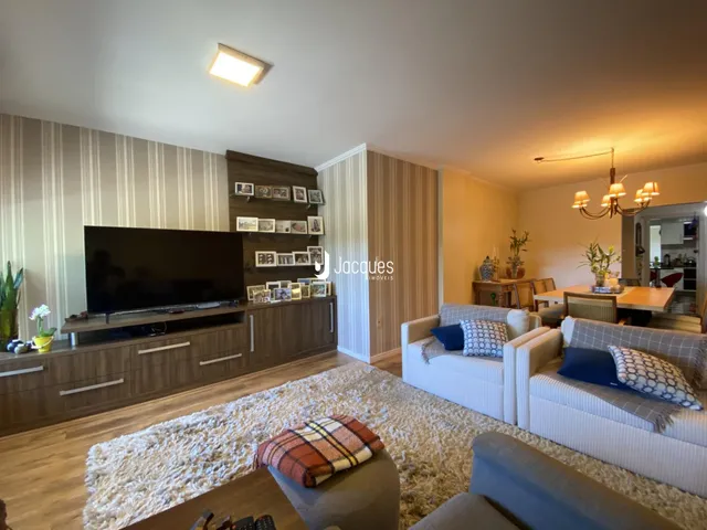 Sala de estar com sofá e televisão em um ambiente moderno.