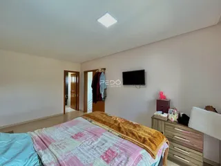 Foto de um quarto com cama e televisão em um imóvel.