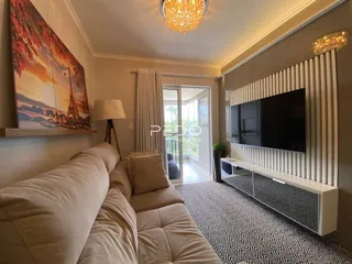 Esta é uma sala de estar com um sofá e uma televisão.