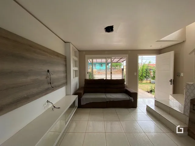 Sala de estar com piso de cerâmica e sofá marrom.