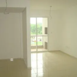 Ambiente interno claro com piso de porcelanato e grande janela.