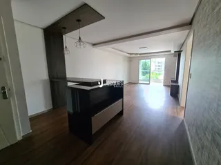 Interior de uma sala com piso de madeira e teto de madeira aparente.
