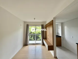 Hall de entrada com piso de madeira e porta de vidro que dá para a área externa.