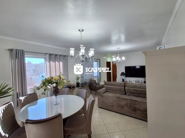 Sala de estar com mesa de jantar e vista para o exterior.