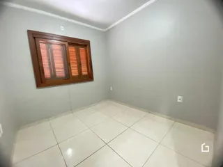 Vista interna de um cômodo com moldura de madeira na parede.