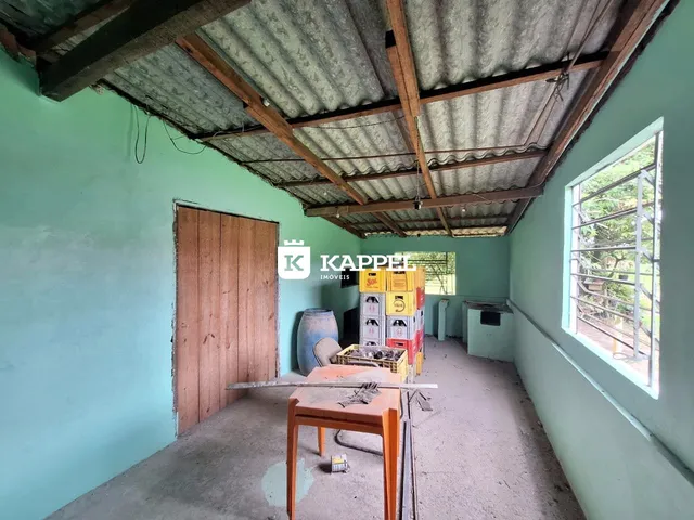 Foto de um cômodo com estrutura de teto exposta e paredes de cor verde clara.