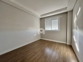 Ambiente interno de uma sala com piso de madeira e paredes cinzas.