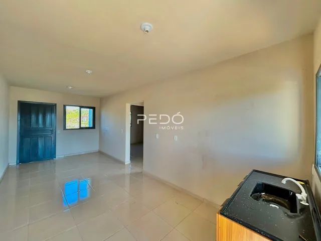Interior de uma área comum com piso de cerâmica e portas em uma residência.