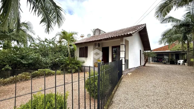 Foto da fachada de uma residência em Lajeado, Brasil, com cerca e vegetação.