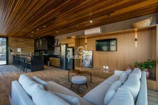 Sala de estar com piso de madeira e decoração moderna em Lajeado.