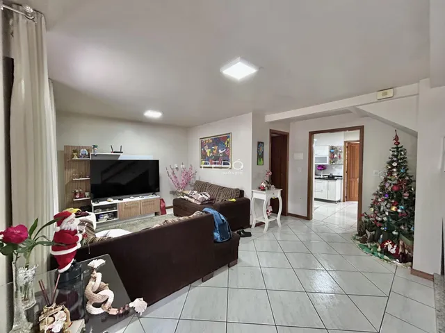 Sala de estar com sofá e televisão em ambiente claro.