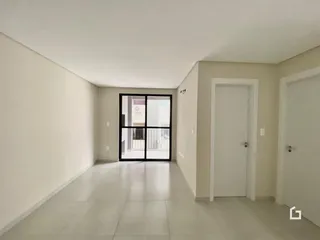 Corredor interno de uma residência com paredes brancas e piso claro.