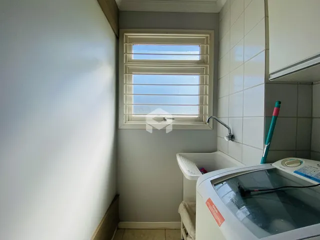 Foto interna de um banheiro com janela e máquina de lavar roupa.