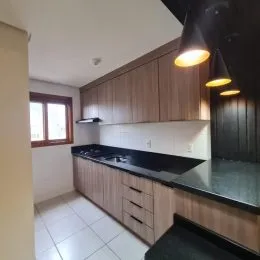 Foto de uma cozinha com armários de madeira e bancada escura.