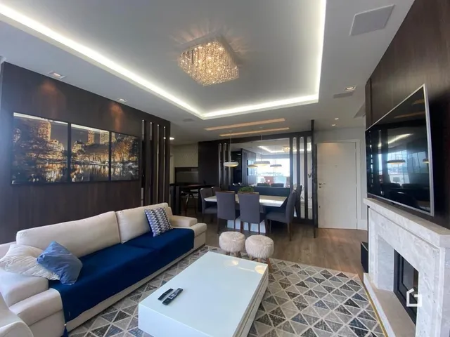 Sala de estar moderna com sofá azul e piso de cerâmica.
