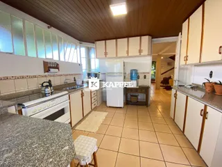 Cozinha com armários brancos e piso de cerâmica.