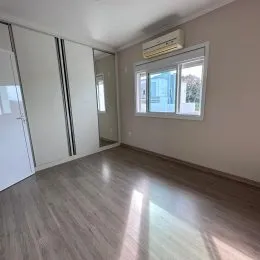 Ambiente interno com piso de madeira e janela em um imóvel.
