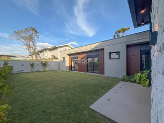Fachada de uma casa moderna com jardim gramado.