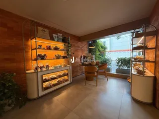 Ambiente interno com paredes de tijolo aparente e estantes de exposição.