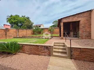 Fachada de um imóvel com muro de tijolos e jardim em Lajeado.