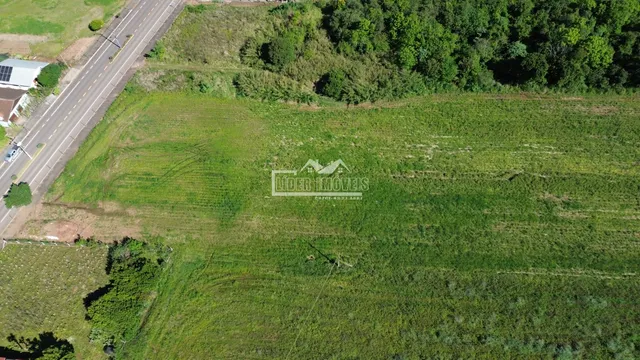Vista aérea de uma área de terreno com vegetação e uma estrada.