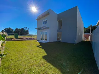 Fachada de uma casa moderna com gramado verde em Lajeado.