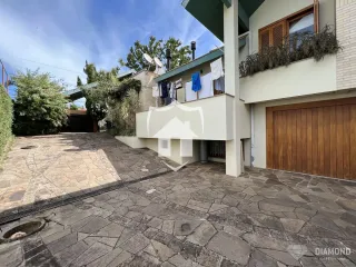 Vista da fachada de uma residência em Lajeado, Brasil, com área externa pavimentada.