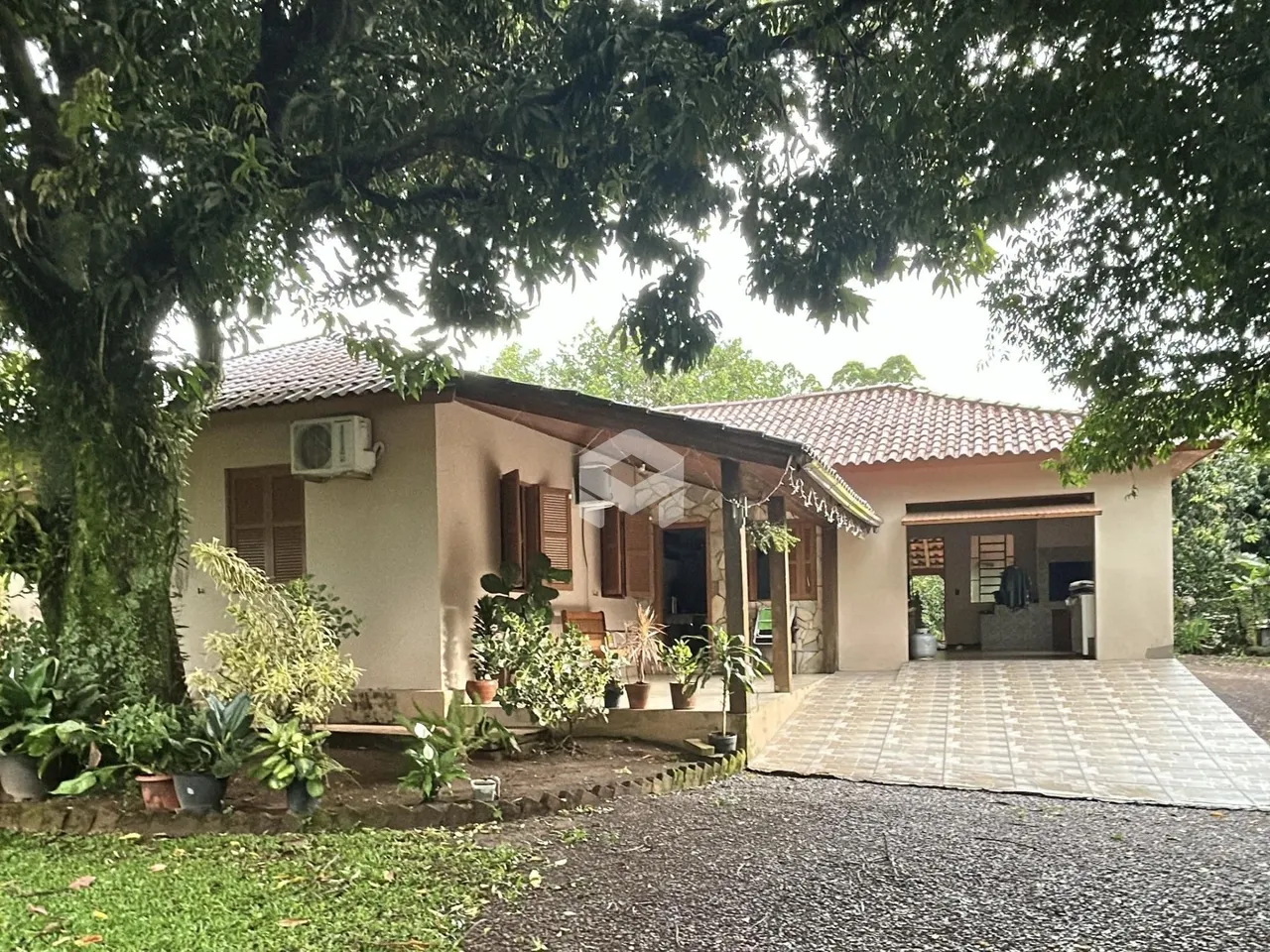 Fachada de uma casa em Lajeado, Brasil, com jardim e entrada pavimentada.