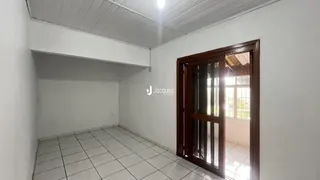 Interior de uma sala com piso de cerâmica e porta de madeira.
