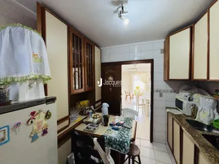 Interior de uma sala de jantar com armários de madeira e porta de acesso a outra área.