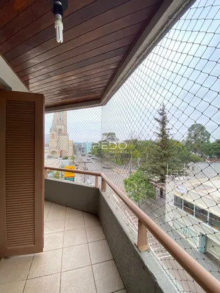Vista de uma varanda com piso de cerâmica e grade de segurança.