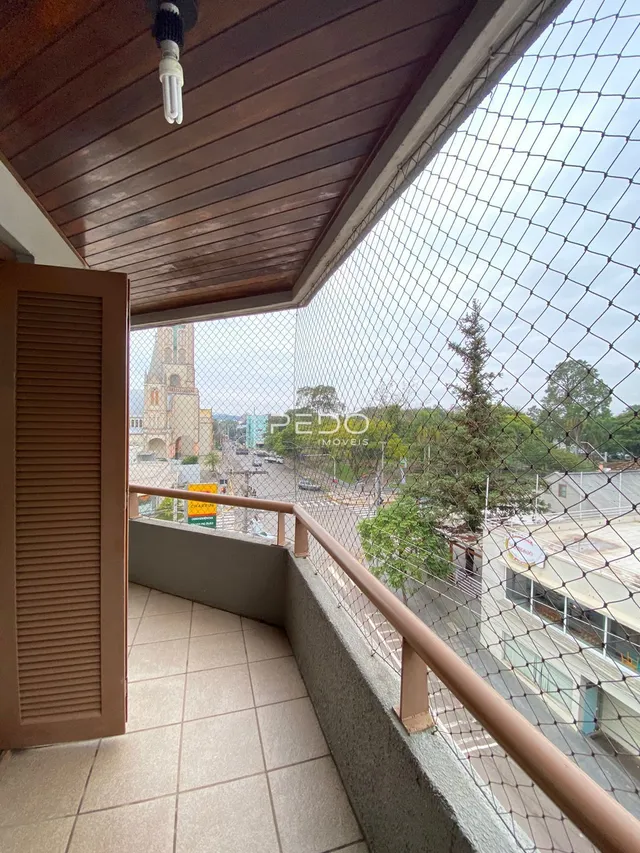 Vista de uma varanda com piso de cerâmica e grade de segurança.