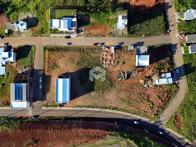 Vista aérea de um terreno residencial em Lajeado, Brasil, mostrando várias construções e áreas de vegetação.