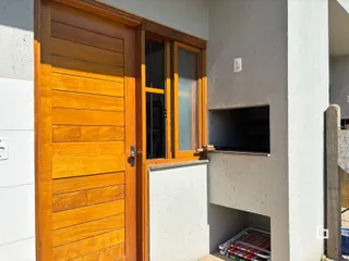 Fachada de uma residência com porta de madeira e janela.