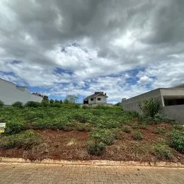 Foto da fachada de uma propriedade com vegetação no primeiro plano.