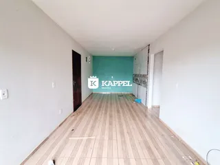 Corredor interno com piso de madeira e parede turquesa.