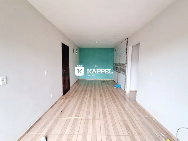 Corredor interno com piso de madeira e parede turquesa.