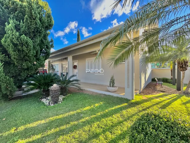 Fachada de uma residência em Lajeado, Brasil, com jardim verde e vegetação.