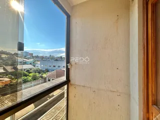 A parede interna de uma residência em Lajeado, Brasil, mostra uma vista externa através de uma janela.