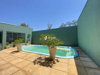 Foto de uma piscina externa em um terreno com parede verde.