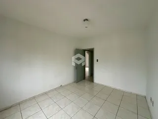 Vista interna de um ambiente com piso de cerâmica e paredes brancas.
