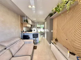 Sala de estar com sofá e cozinha integrada em um ambiente moderno.