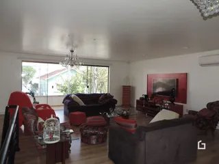 Sala de estar com sofá e piso de madeira na residência.