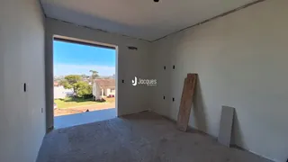Ambiente interno com paredes brancas e piso de concreto.